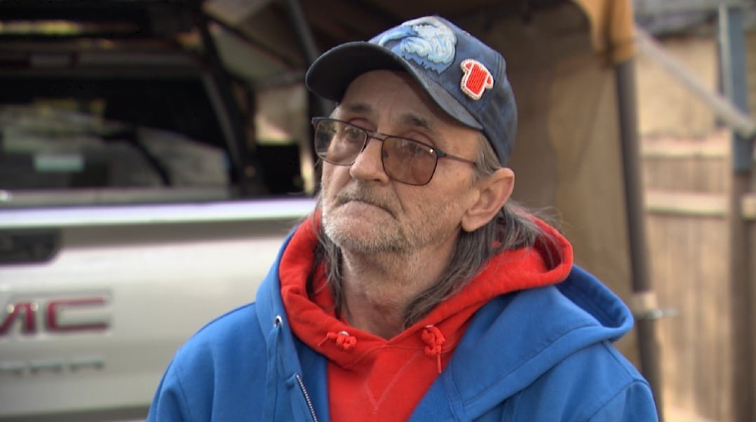 A man in a baseball cap gazes ahead.